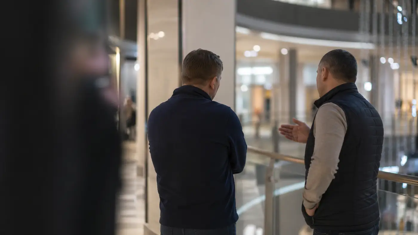 Dvaja muži v nákupnom centre během rozhovoru, který se stal podnetom k úvahe o dostupnsti důstojného úsměvu.